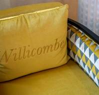 Yellow cushion with Willicombe branding