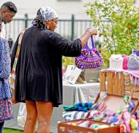 Customers examine crochet bag at stall