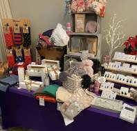 A display table with socks, knit hats, gift boxes, jewelry, and various small gift items arranged for sale.